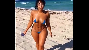 Latina sexy en mini bikini en la playa
