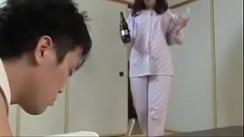 Matrigna giapponese con figlio beve e scopa