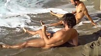 Dos amigos gays acariciando en la playa