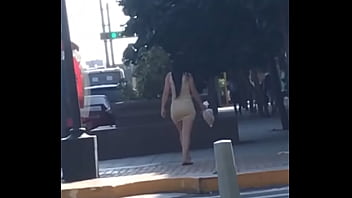 Der vollmundige Venezolaner geht in gestreiftem Kleid die Straße entlang