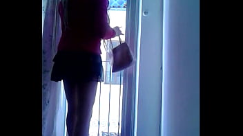 Lili cd sumisa con tacones rojos se asoma al balcón para recibir un cliente