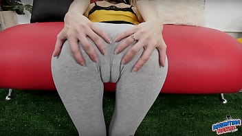 Une fille maigre a un gros écart entre les cuisses et un cul rond dans un pantalon de yoga serré