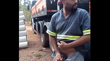 Un ouvrier se masturbe sur un chantier de construction caché derrière le camion de l'entreprise